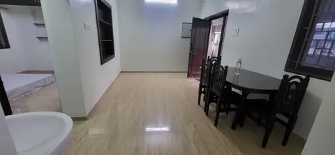 Living hall with a round dining table and four chairs, and the door to the porch