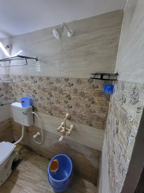 Western WC with hand shower and wall mixer tap against patterned tiles